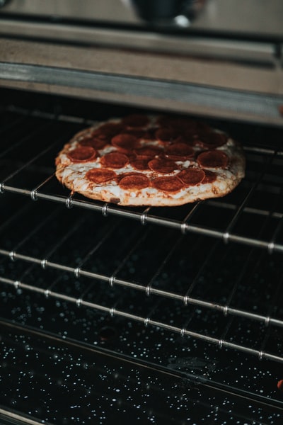 Brown and white on black metal grill pizza
